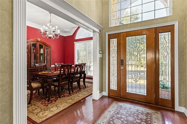 entrance foyer featuring a wealth of natural light, a notable chandelier, and hardwood / wood-style flooring