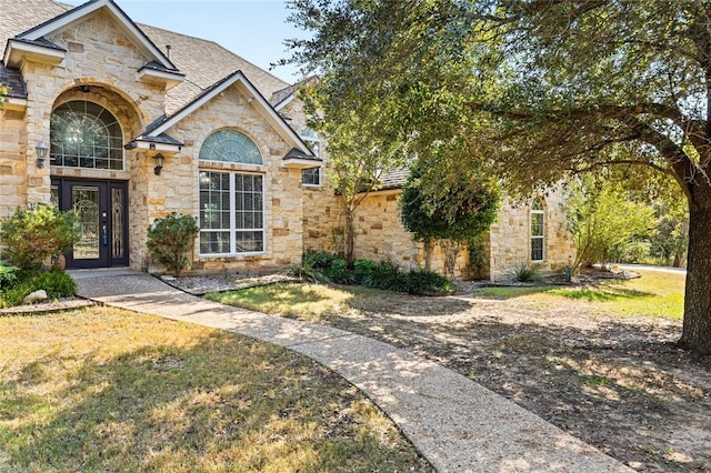 view of front of house featuring a front yard and french doors