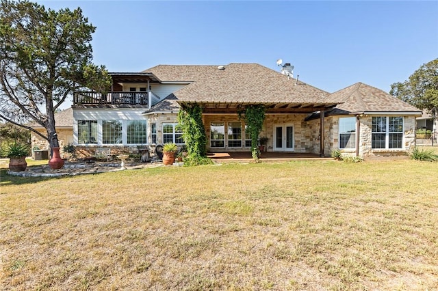 back of house with a lawn, a balcony, and french doors