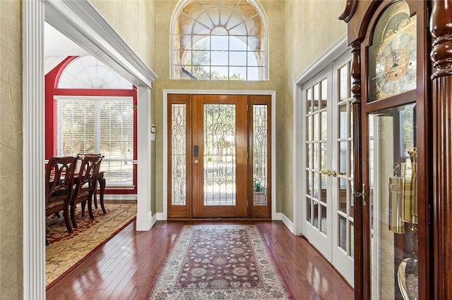 entrance foyer with dark hardwood / wood-style flooring, french doors, and a towering ceiling