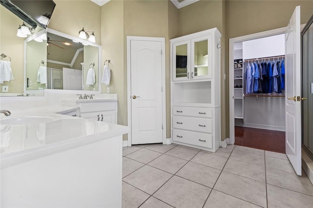 bathroom with ornamental molding, vanity, ceiling fan, tile patterned flooring, and a shower with shower door