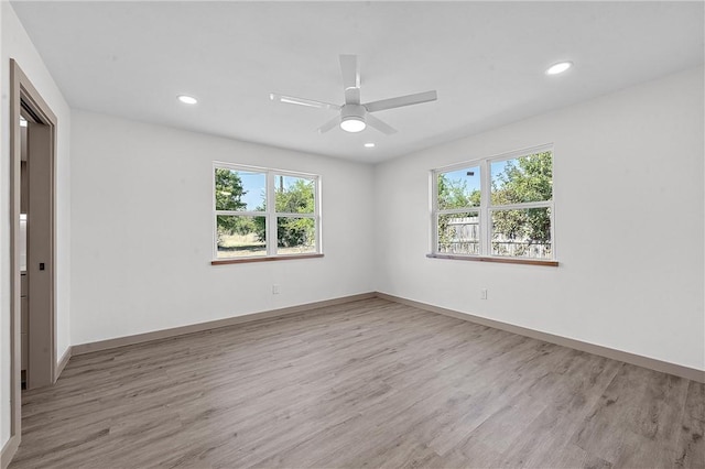 unfurnished room with plenty of natural light, ceiling fan, and light wood-type flooring