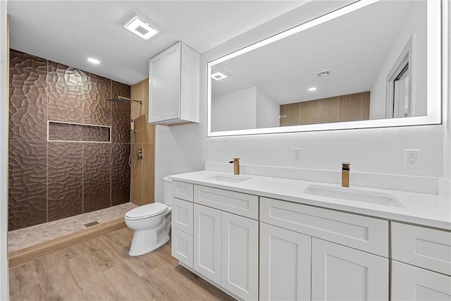 bathroom featuring toilet, hardwood / wood-style floors, vanity, and walk in shower