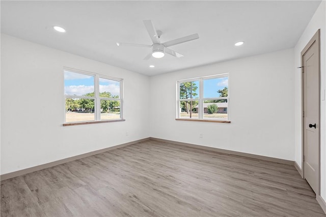 unfurnished bedroom with hardwood / wood-style flooring, ceiling fan, and multiple windows