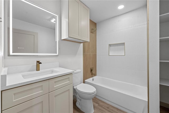 full bathroom with hardwood / wood-style flooring, tiled shower / bath combo, toilet, and vanity