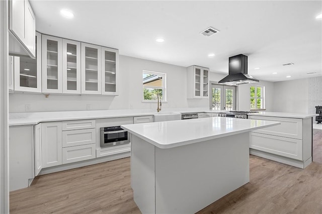 kitchen with kitchen peninsula, sink, a center island, and exhaust hood