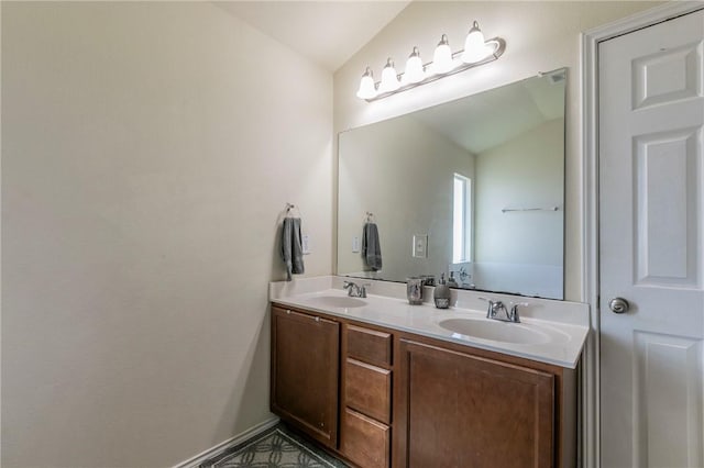 bathroom with vanity and lofted ceiling