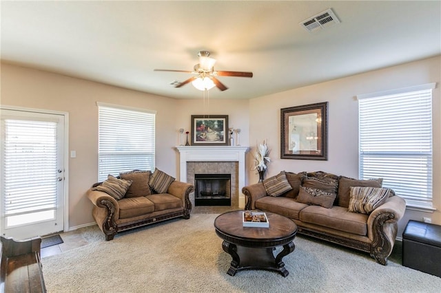 living room featuring ceiling fan, a fireplace, and wood-type flooring