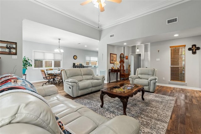 living room with crown molding, dark wood-type flooring, and ceiling fan with notable chandelier