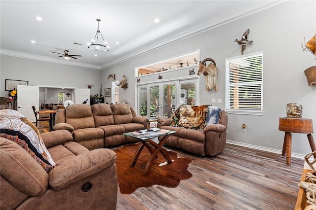 living room featuring french doors, ornamental molding, a chandelier, and wood-type flooring