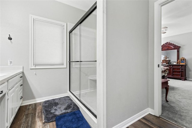 bathroom featuring wood-type flooring, a shower with shower door, and vanity