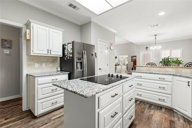 kitchen with white cabinetry, stainless steel fridge with ice dispenser, hanging light fixtures, a kitchen island, and black electric stovetop