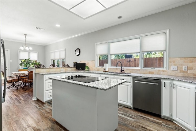 kitchen featuring sink, hanging light fixtures, white cabinets, a kitchen island, and stainless steel dishwasher