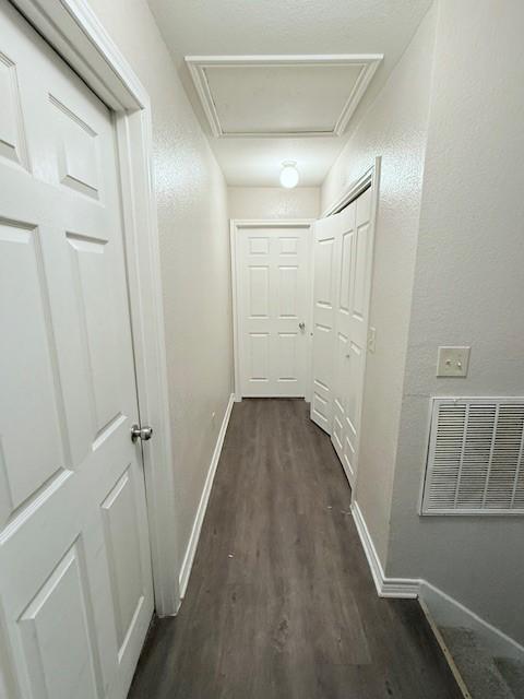 hall with dark wood-type flooring and ornamental molding