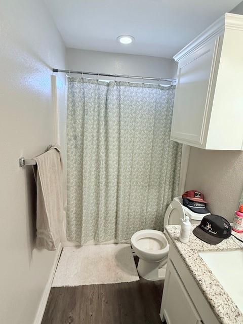 bathroom featuring vanity, hardwood / wood-style floors, a shower with curtain, and toilet