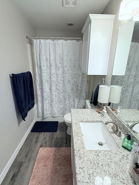 bathroom with vanity, hardwood / wood-style floors, and toilet