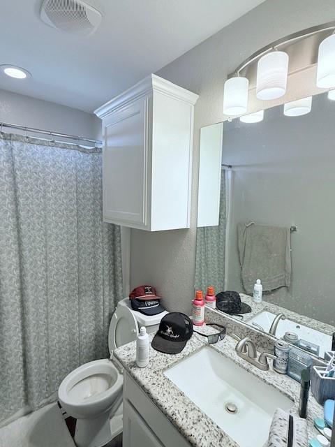 bathroom featuring vanity, curtained shower, and toilet