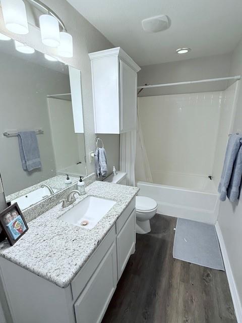 full bathroom featuring shower / bathing tub combination, vanity, hardwood / wood-style flooring, and toilet