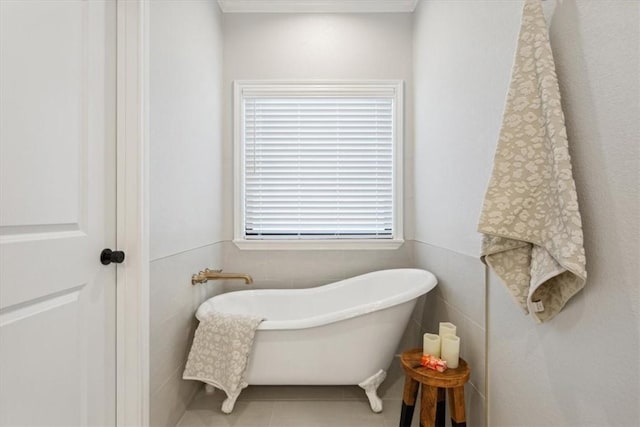 bathroom with a washtub, tile patterned floors, and tile walls