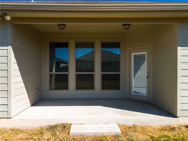 view of exterior entry featuring a patio