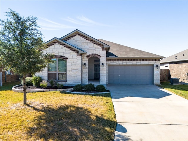 view of front of home featuring a garage, a front yard, and central air condition unit