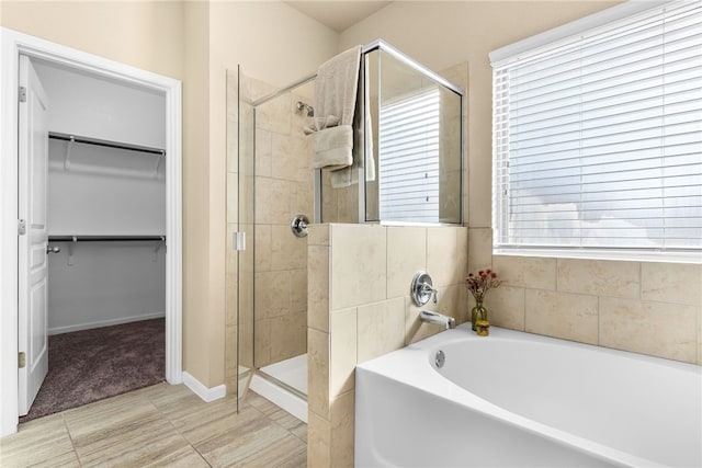 bathroom featuring shower with separate bathtub