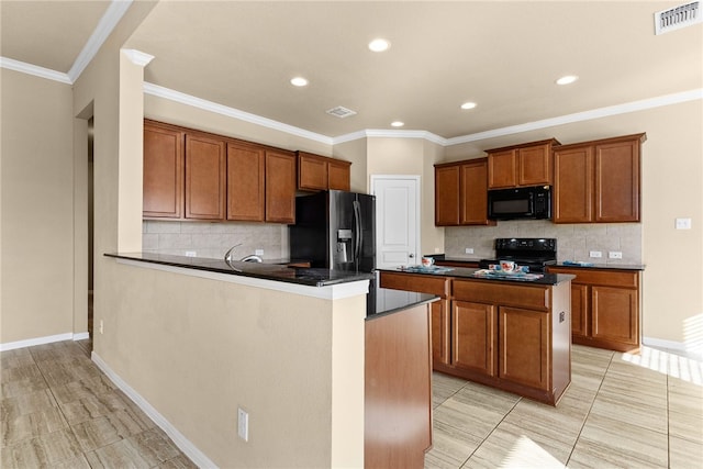 kitchen featuring backsplash, ornamental molding, a kitchen island, and black appliances