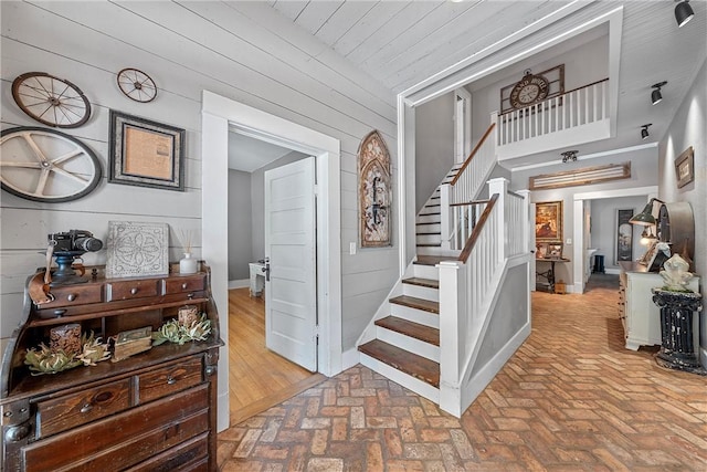 stairway featuring wood walls