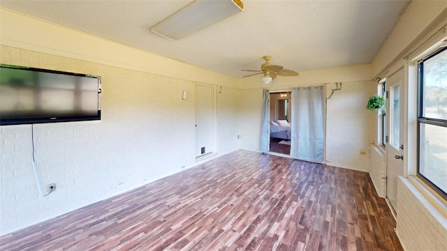 spare room featuring a textured ceiling, ceiling fan, and dark wood-type flooring