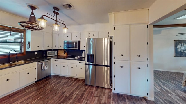 kitchen with sink, white cabinetry, stainless steel appliances, and dark wood-type flooring