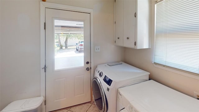 laundry room featuring washer and dryer, light tile patterned flooring, and cabinets