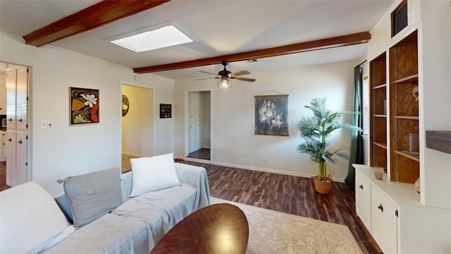 living room with beam ceiling, a skylight, ceiling fan, and dark wood-type flooring