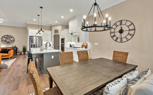 dining area with crown molding, sink, and hardwood / wood-style flooring