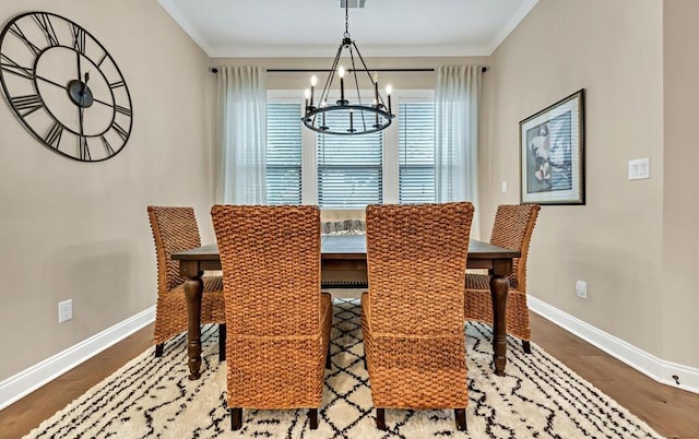 dining room featuring crown molding, hardwood / wood-style floors, and a notable chandelier