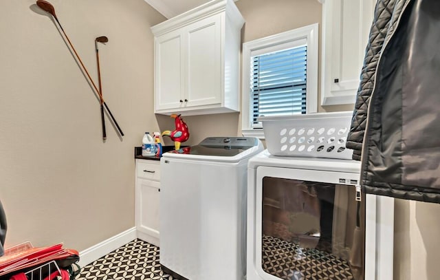 washroom featuring cabinets and washer and clothes dryer