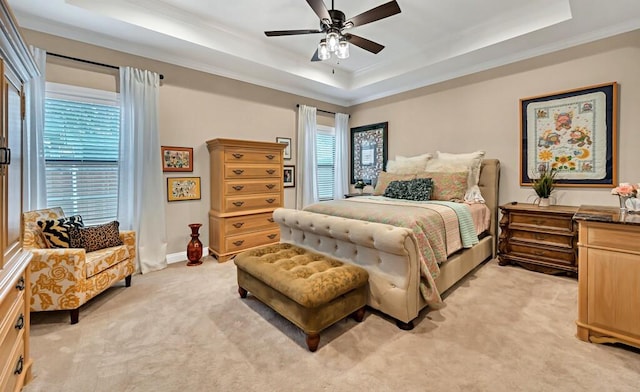 carpeted bedroom featuring ceiling fan and a tray ceiling