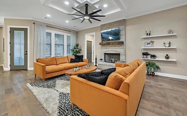 living room featuring coffered ceiling, hardwood / wood-style floors, crown molding, and a fireplace