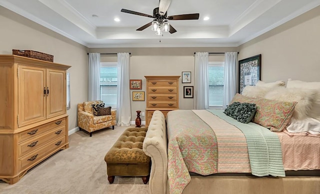 carpeted bedroom featuring a tray ceiling, ornamental molding, and ceiling fan