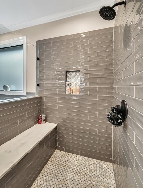 bathroom with crown molding and tiled shower