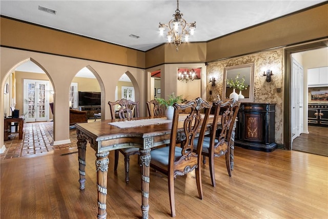 dining room with light wood-type flooring, ornamental molding, and a chandelier