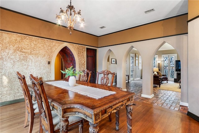 dining area with wood-type flooring and a chandelier