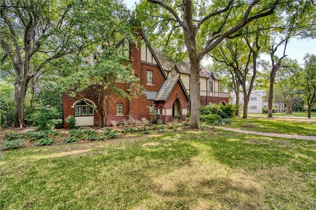 tudor-style house featuring a front yard