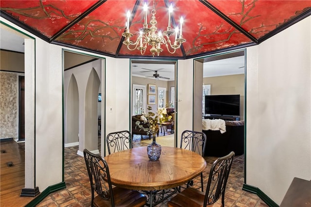 dining space featuring ceiling fan with notable chandelier