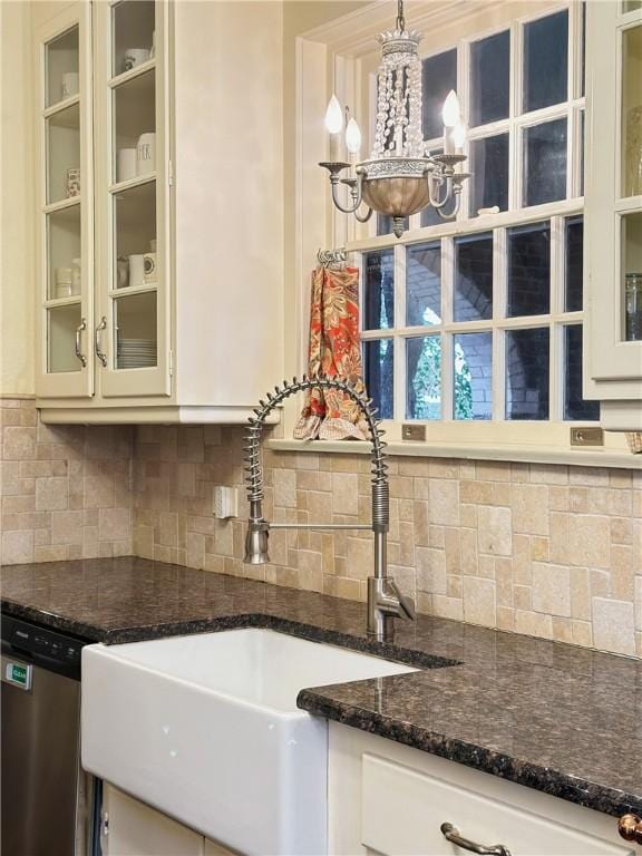 kitchen featuring tasteful backsplash, sink, pendant lighting, dark stone countertops, and dishwasher