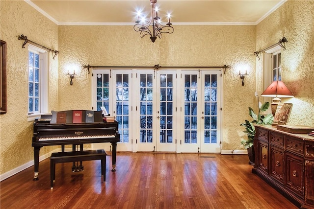 misc room featuring hardwood / wood-style floors, french doors, crown molding, and a chandelier