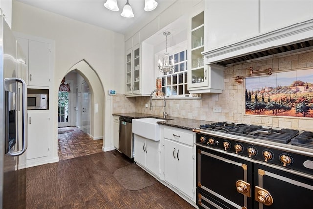 kitchen with pendant lighting, sink, decorative backsplash, appliances with stainless steel finishes, and white cabinetry