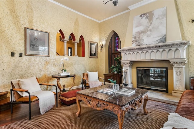 living area featuring a fireplace, hardwood / wood-style flooring, and crown molding