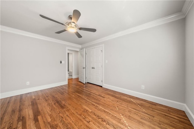 empty room with hardwood / wood-style flooring, ceiling fan, and crown molding