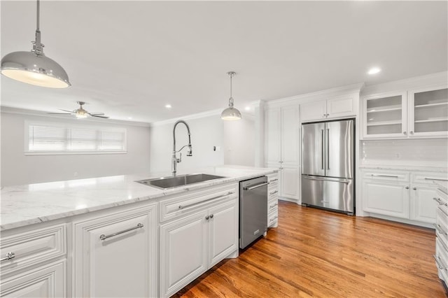 kitchen featuring appliances with stainless steel finishes, ceiling fan, sink, white cabinets, and light hardwood / wood-style floors