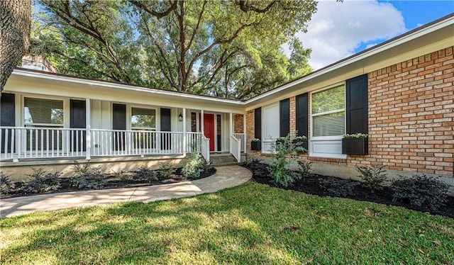 ranch-style home with a porch and a front lawn